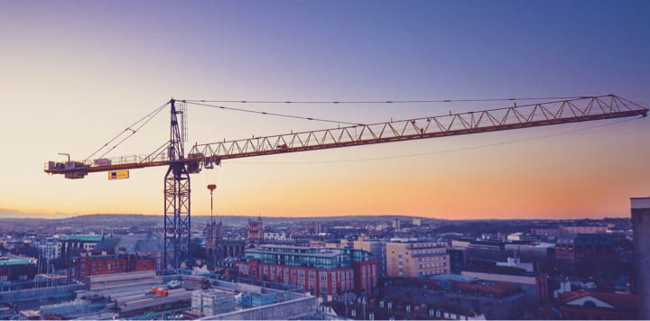 A massive crane overlooking a city